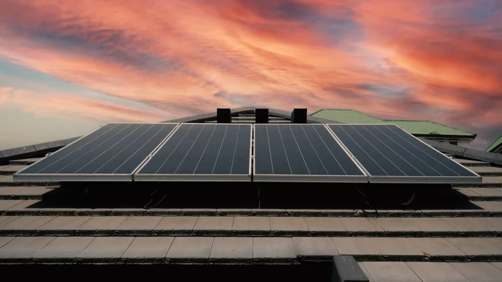solar panels on roof with sunset