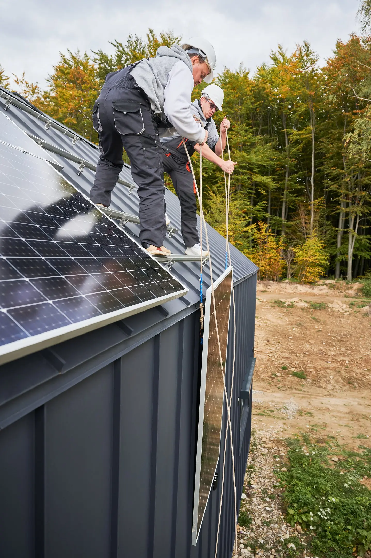 blusolar team lifting solar panels onto roof
