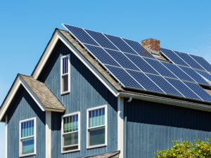 blue house with solar panels on shingle roof in Denver, Colorado
