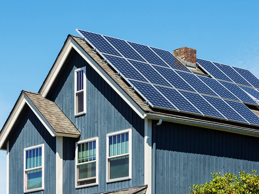 blue house with solar panels on shingle roof in Denver, Colorado